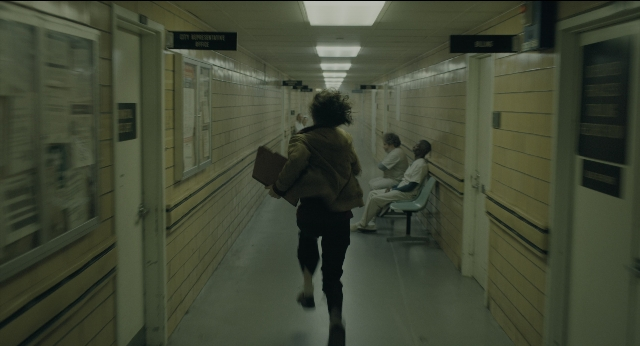 Wide shot frame from Joker — sitting, walking, hand