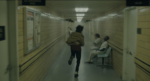 Wide shot frame from Joker — sitting, walking, hair