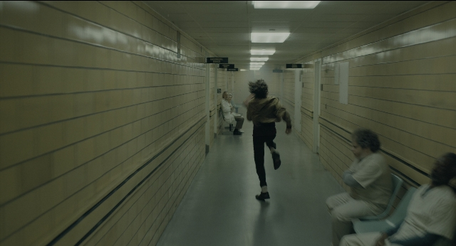 Wide shot frame from Joker — sitting, person, human face