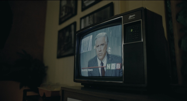 Wide shot frame from Joker — room, table, suit