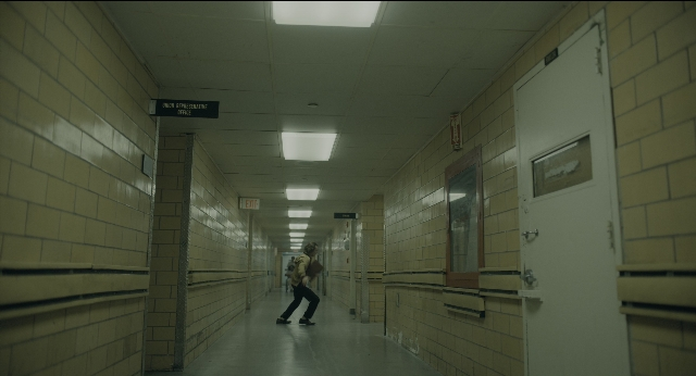 Close-up frame from Joker — door, person, window