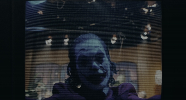 Wide shot frame from Joker — room, suit, television