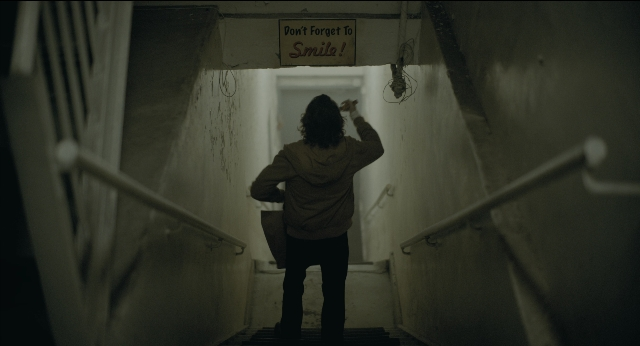 Wide shot frame from Joker — standing, hand, person