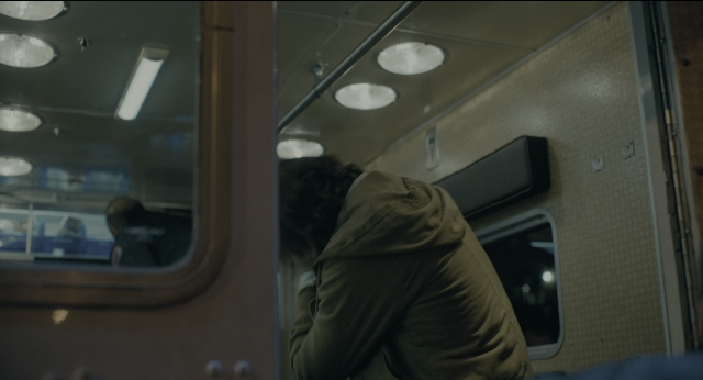 Wide shot frame from Joker — sitting, train, person