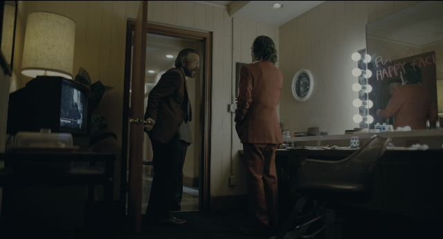 Wide shot frame from Joker — standing, room, door