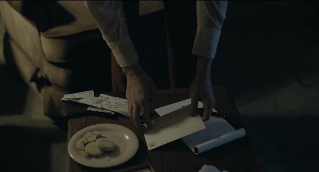 Wide shot frame from Joker — plate, table, person