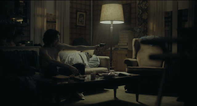 Wide shot frame from Joker — sitting, plate, room