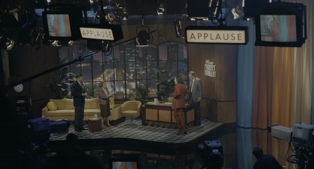 Wide shot frame from Joker — standing, room, table