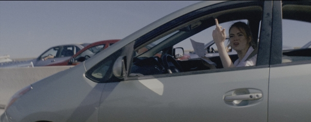 Wide shot frame from La La Land — sitting, car, hand