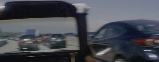 Frame from La La Land — street, mirror, car