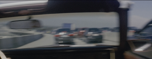 Frame from La La Land — street, mirror, car