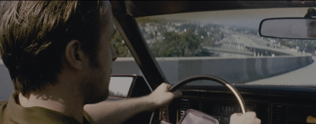 Wide shot frame from La La Land — street, mirror, car