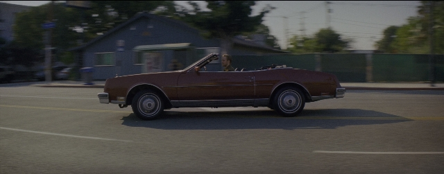 Wide shot frame from La La Land — street, car, wheel