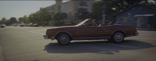 Wide shot frame from La La Land — sitting, street, car