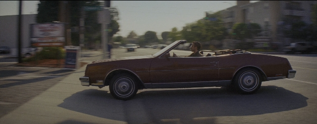 Wide shot frame from La La Land — sitting, street, car