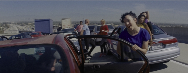 Wide shot frame from La La Land — standing, street, car