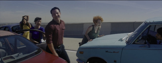 Wide shot frame from La La Land — standing, car, dress