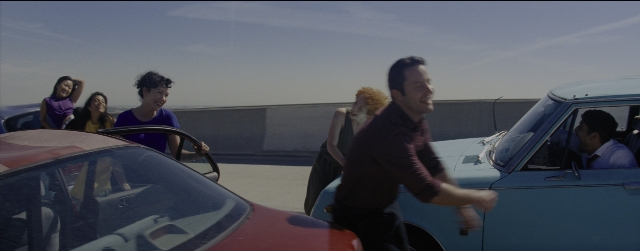 Wide shot frame from La La Land — standing, car, person