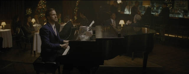 Wide shot frame from La La Land — sitting, suit, restaurant