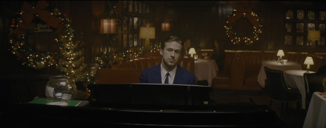 Wide shot frame from La La Land — sitting, table, suit