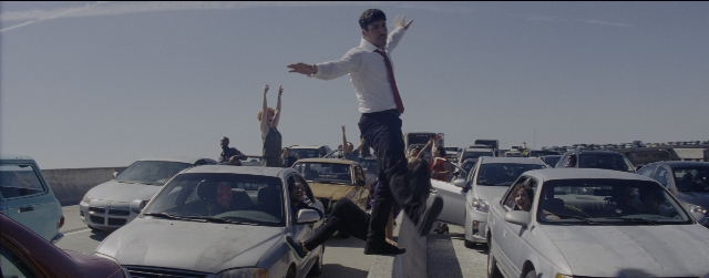 Wide shot frame from La La Land — standing, street, car