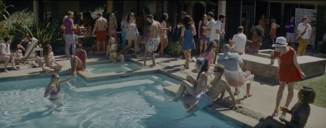 Wide shot frame from La La Land — sitting, standing, dialogue