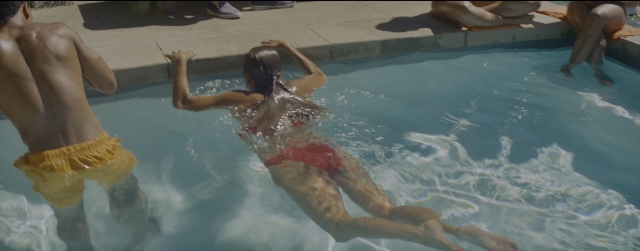 Wide shot frame from La La Land — sitting, standing, water