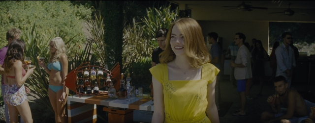 Wide shot frame from La La Land — sitting, standing, table