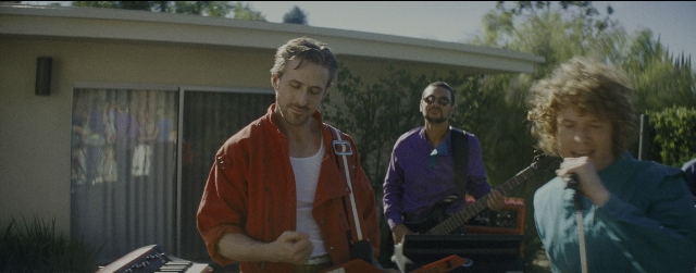Wide shot frame from La La Land — standing, beard, guitar