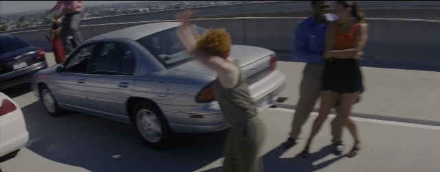 Wide shot frame from La La Land — standing, street, car