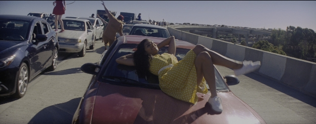 Wide shot frame from La La Land — sitting, street, car