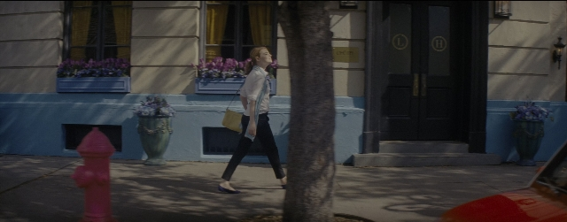 Wide shot frame from La La Land — walking, door, street