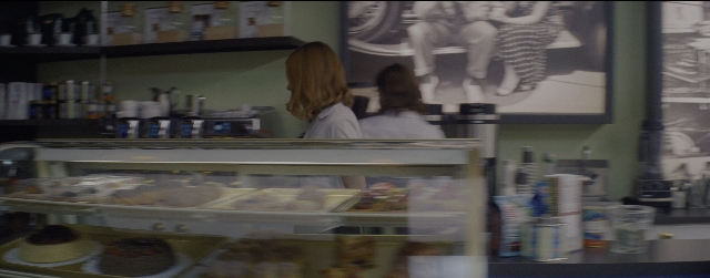 Wide shot frame from La La Land — sitting, restaurant, person