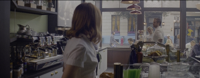 Wide shot frame from La La Land — sitting, standing, street
