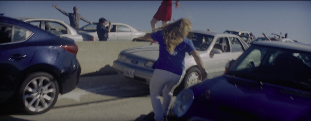 Wide shot frame from La La Land — standing, car, hand