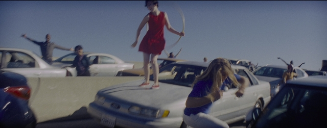 Wide shot frame from La La Land — standing, hat, car