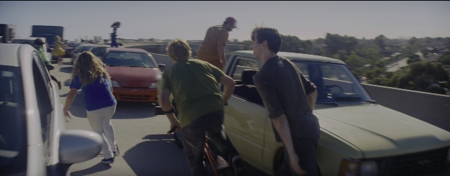 Wide shot frame from La La Land — walking, street, car