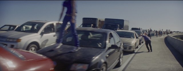 Wide shot frame from La La Land — walking, street, car