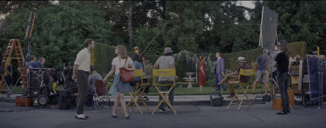 Wide shot frame from La La Land — sitting, standing, dialogue