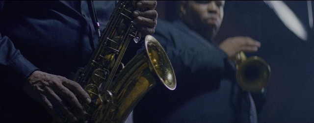 Wide shot frame from La La Land — shirt, saxophone, person
