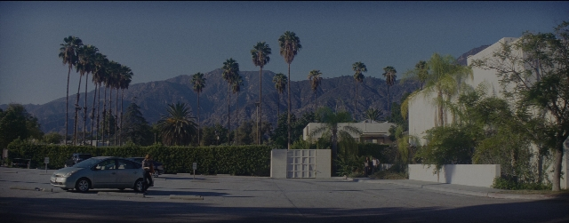Wide shot frame from La La Land — walking, street, car