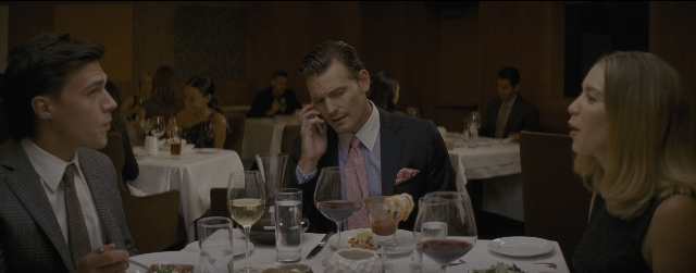 Wide shot frame from La La Land — sitting, table, suit