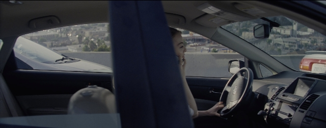 Wide shot frame from La La Land — sitting, car, shirt