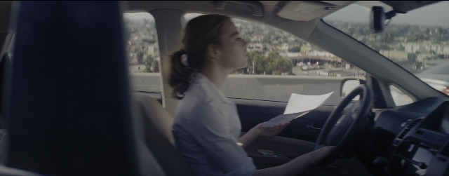 Wide shot frame from La La Land — sitting, car, shirt