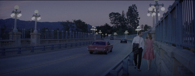 Wide shot frame from La La Land — walking, street, car