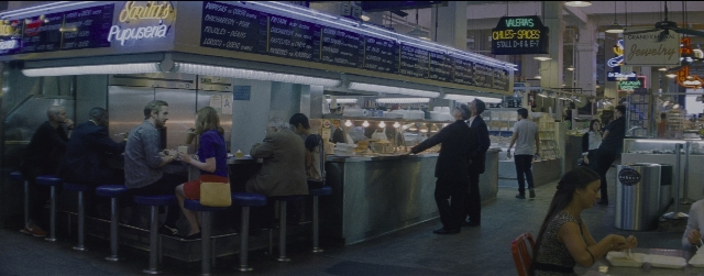 Wide shot frame from La La Land — sitting, standing, table