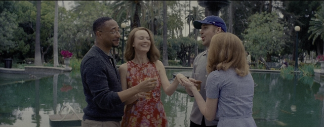 Wide shot frame from La La Land — standing, hat, dress