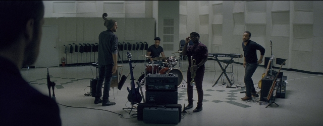 Wide shot frame from La La Land — standing, room, drum