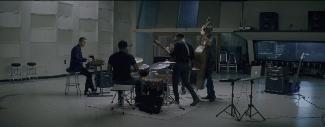Wide shot frame from La La Land — sitting, standing, room