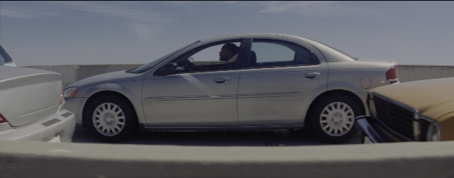 Frame from La La Land — sitting, street, car
